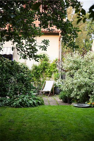 photo of apple tree in bloom - Back garden and sun chair Stock Photo - Premium Royalty-Free, Code: 6102-07844171