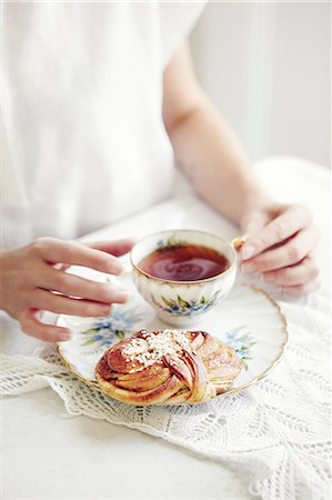 Hands with tea and bun Stock Photo - Premium Royalty-Free, Code: 6102-08062973