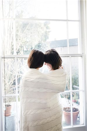 Couple wrapped in blanket looking Stock Photo - Premium Royalty-Free, Code: 6102-08062970