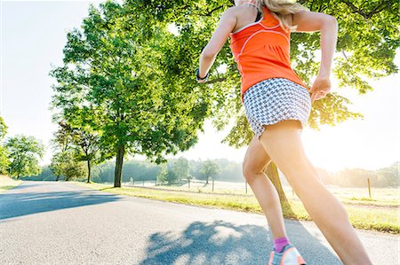 simsearch:6102-08481170,k - Woman jogging on country road Foto de stock - Royalty Free Premium, Número: 6102-08062975