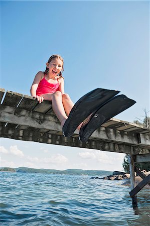 Happy girl wearing flippers on jetty Foto de stock - Sin royalties Premium, Código: 6102-08063042