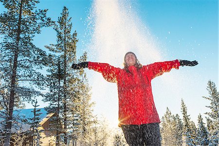 sweden, winter - Mature woman throwing snow Stock Photo - Premium Royalty-Free, Code: 6102-08063109