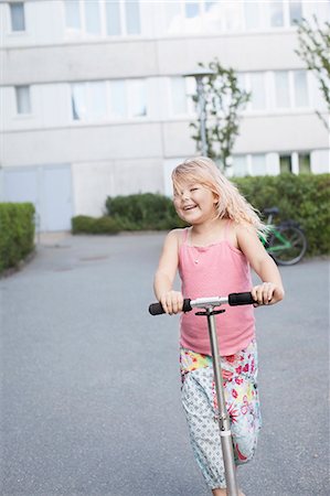 Happy girl on scooter Stock Photo - Premium Royalty-Free, Code: 6102-08000690