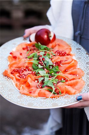 smoked salmon - Person holding tray with smoked salmon and pomegranate seeds Stock Photo - Premium Royalty-Free, Code: 6102-08000708
