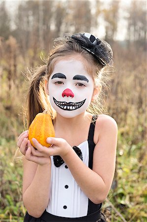 simsearch:6102-08000828,k - Portrait of girl with painted face holding pumpkin Stock Photo - Premium Royalty-Free, Code: 6102-08000827