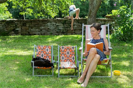 pre teen girl and mother - Woman reading book on sun chair Stock Photo - Premium Royalty-Free, Code: 6102-08000909