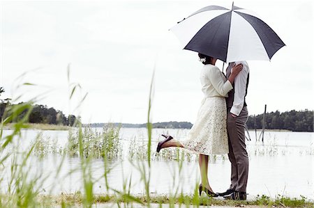 europe beach people photo - Bride and groom standing at lake Stock Photo - Premium Royalty-Free, Code: 6102-08001089