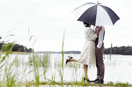 Bride and groom standing at lake Foto de stock - Sin royalties Premium, Código: 6102-08001089