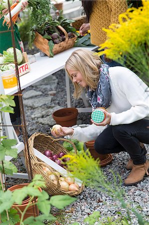 simsearch:6102-07769055,k - Young woman looking at home-grown vegetables Stock Photo - Premium Royalty-Free, Code: 6102-08001163