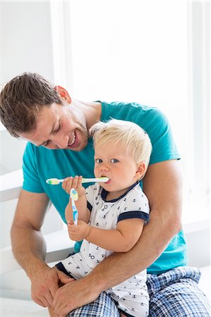 father son bathroom not illustration not monochrome - Father and son brushing teeth together Stock Photo - Premium Royalty-Free, Code: 6102-08001126