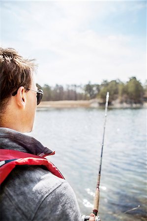 Young man fishing Stock Photo - Premium Royalty-Free, Code: 6102-08001384