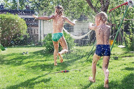 Boy and girl playing in garden Stock Photo - Premium Royalty-Free, Code: 6102-08001466