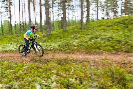 simsearch:6102-08388011,k - Boy cycling through forest Photographie de stock - Premium Libres de Droits, Code: 6102-08168654