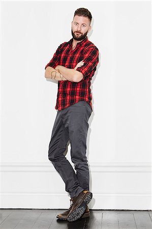 single man standing - Young man wearing checked shirt, studio shot Stock Photo - Premium Royalty-Free, Code: 6102-08168722