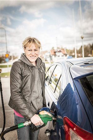 poner gasolina - Smiling woman fueling car Stock Photo - Premium Royalty-Free, Code: 6102-08184013