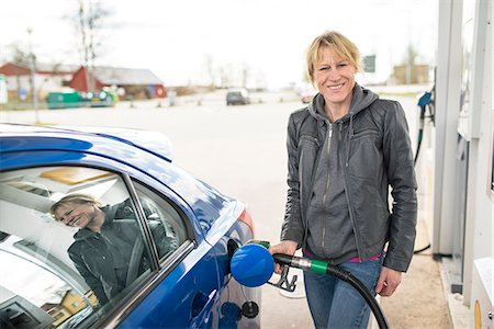 simsearch:6102-08885482,k - Smiling woman fueling car Foto de stock - Royalty Free Premium, Número: 6102-08184012