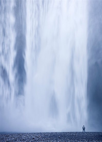 Person in front of waterfall Stock Photo - Premium Royalty-Free, Image code: 6102-08184150