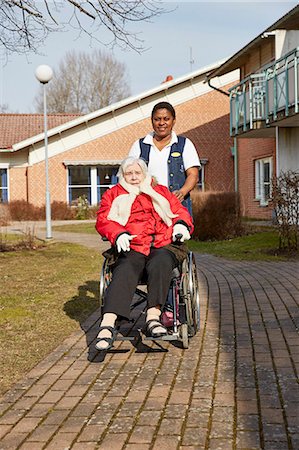 simsearch:6102-08184209,k - Nurse on walk with senior woman on wheelchair Stock Photo - Premium Royalty-Free, Code: 6102-08184229