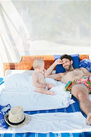 simsearch:6102-07602780,k - Father with baby relaxing on outdoor bed Foto de stock - Sin royalties Premium, Código: 6102-08120352