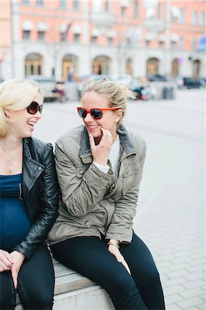 simsearch:6102-08885673,k - Happy female friends sitting together Stock Photo - Premium Royalty-Free, Code: 6102-08120386