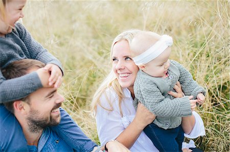 simsearch:6102-08761638,k - Parents with children on meadow Foto de stock - Royalty Free Premium, Número: 6102-08120405