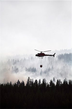 forest fire silhouette - Helicopter dumping water on forest fire Stock Photo - Premium Royalty-Free, Code: 6102-08120506