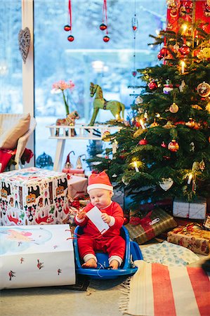 Baby in Santa hat near Christmas tree Stock Photo - Premium Royalty-Free, Code: 6102-08120513