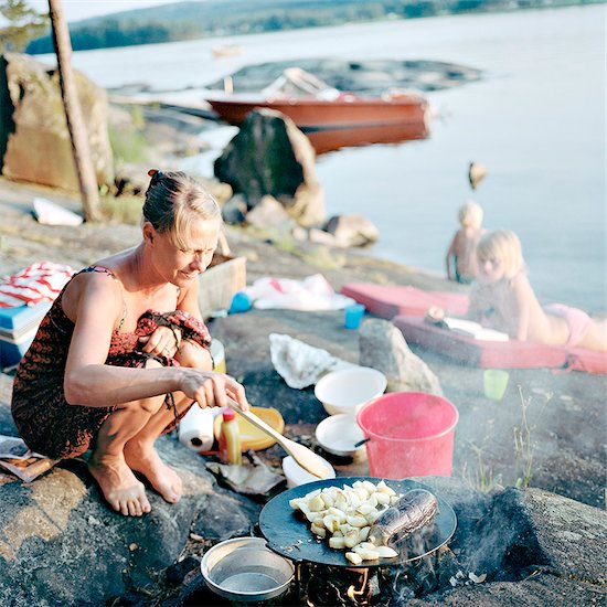 Mother preparing food at water Stock Photo - Premium Royalty-Free, Image code: 6102-08120532