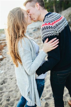 simsearch:6102-08270736,k - Young couple kissing on beach Foto de stock - Royalty Free Premium, Número: 6102-08120664