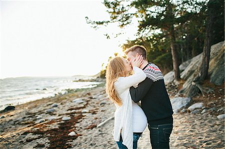 simsearch:6102-08120677,k - Young couple kissing on beach Fotografie stock - Premium Royalty-Free, Codice: 6102-08120665