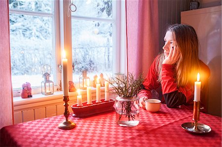 Young woman looking through window Stock Photo - Premium Royalty-Free, Code: 6102-08120851