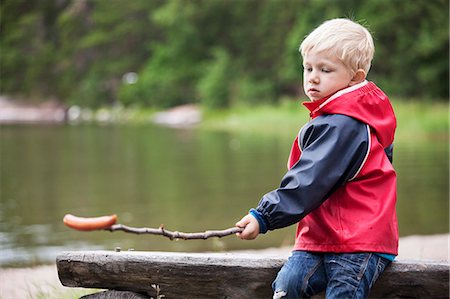 Boy with sausage on stick Stock Photo - Premium Royalty-Free, Code: 6102-08120831