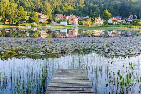 Buildings reflecting in lake Photographie de stock - Premium Libres de Droits, Code: 6102-08120952