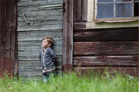 simsearch:6102-08120333,k - Boy standing near wooden house Foto de stock - Sin royalties Premium, Código: 6102-08270873