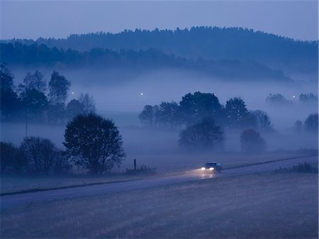 simsearch:6102-08542140,k - Car on country road at foggy evening Foto de stock - Royalty Free Premium, Número: 6102-08271379