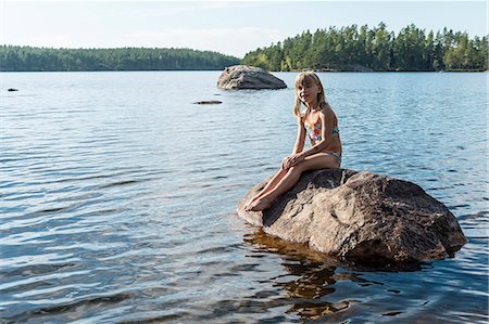 Girl on rock in lake Photographie de stock - Premium Libres de Droits, Code: 6102-08271455