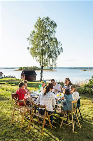Family having meal at lake Photographie de stock - Premium Libres de Droits, Code: 6102-08271434