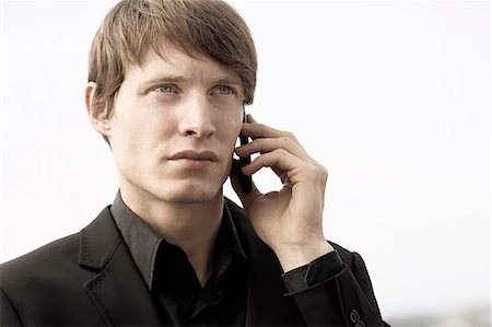 simsearch:6102-08566469,k - Young man talking through cell phone Stock Photo - Premium Royalty-Free, Code: 6102-08271701