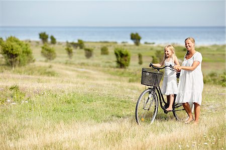 simsearch:6102-08271741,k - Mother with daughter on bicycle Fotografie stock - Premium Royalty-Free, Codice: 6102-08271833