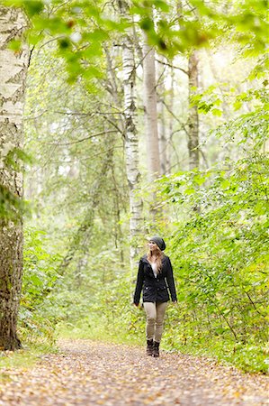 simsearch:6102-08120677,k - Woman walking in forest Fotografie stock - Premium Royalty-Free, Codice: 6102-08278805