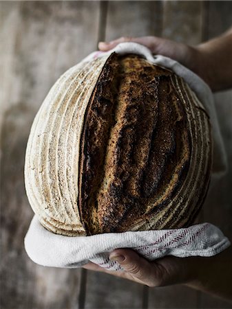 simsearch:6102-08271764,k - Hands with fresh loaf of bread Photographie de stock - Premium Libres de Droits, Code: 6102-08278829