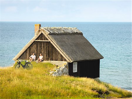 Couple sitting near wooden house at sea Stock Photo - Premium Royalty-Free, Code: 6102-08278907