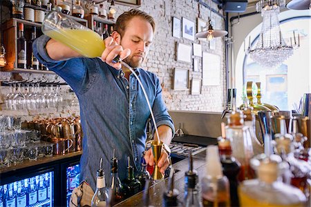 simsearch:6102-08384068,k - Barman preparing drink behind bar Foto de stock - Sin royalties Premium, Código: 6102-08384069