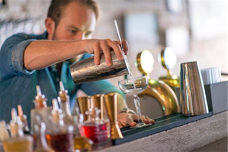 simsearch:6102-08384068,k - Barman preparing drink behind bar Foto de stock - Sin royalties Premium, Código: 6102-08384070