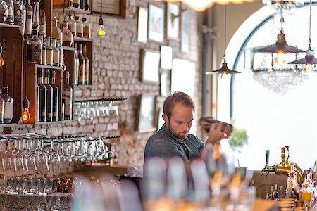 Barman preparing drink behind bar Photographie de stock - Premium Libres de Droits, Code: 6102-08384071