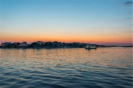 Coastal buildings at sunset, boat on foreground Stockbilder - Premium RF Lizenzfrei, Bildnummer: 6102-08384149