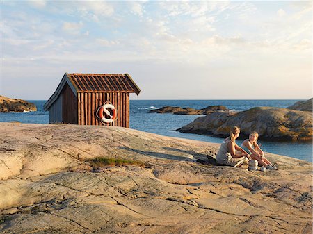 Mother with daughter sitting at sea Stock Photo - Premium Royalty-Free, Code: 6102-08384123