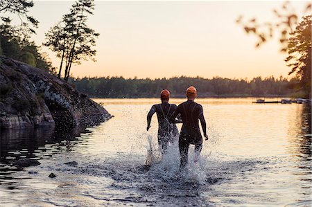 swim cap back view - People running in water at sunset Foto de stock - Sin royalties Premium, Código: 6102-08388049