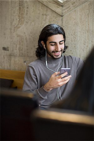 Young man in cafe listening music Stock Photo - Premium Royalty-Free, Code: 6102-08388093