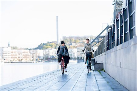 simsearch:6102-08480903,k - Women riding bicycles on promenade Photographie de stock - Premium Libres de Droits, Code: 6102-08388195
